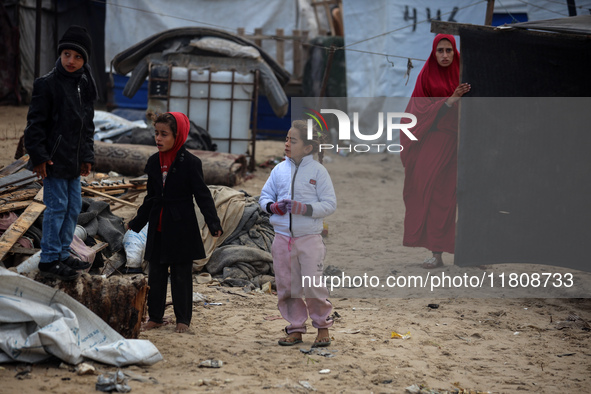 Palestinian displaced persons inspect their tents, which are damaged by wind and rain after heavy rainfall in Deir al-Balah, central Gaza St...