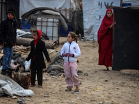 Palestinian displaced persons inspect their tents, which are damaged by wind and rain after heavy rainfall in Deir al-Balah, central Gaza St...