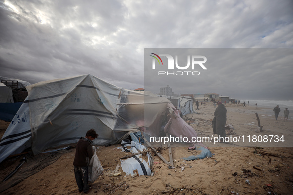 Palestinian displaced persons inspect their tents, which are damaged by wind and rain after heavy rainfall in Deir al-Balah, central Gaza St...