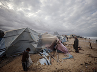 Palestinian displaced persons inspect their tents, which are damaged by wind and rain after heavy rainfall in Deir al-Balah, central Gaza St...