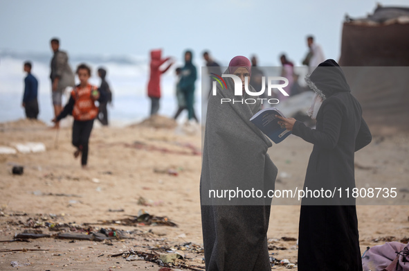 Palestinian displaced persons inspect their tents, which are damaged by wind and rain after heavy rainfall in Deir al-Balah, central Gaza St...