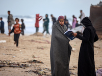 Palestinian displaced persons inspect their tents, which are damaged by wind and rain after heavy rainfall in Deir al-Balah, central Gaza St...