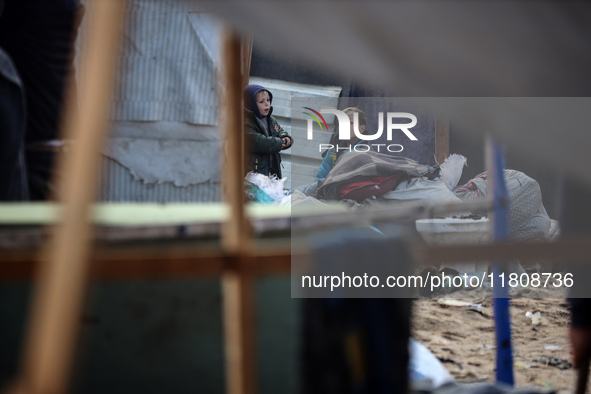 Palestinian displaced persons inspect their tents, which are damaged by wind and rain after heavy rainfall in Deir al-Balah, central Gaza St...