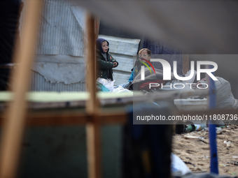 Palestinian displaced persons inspect their tents, which are damaged by wind and rain after heavy rainfall in Deir al-Balah, central Gaza St...