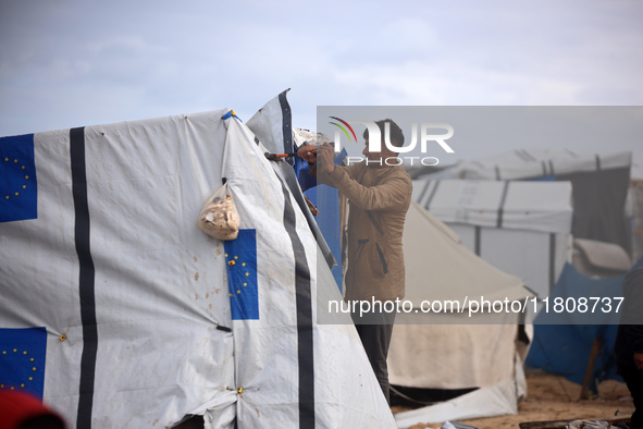 Palestinian displaced persons inspect their tents, which are damaged by wind and rain after heavy rainfall in Deir al-Balah, central Gaza St...