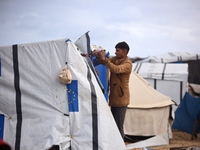 Palestinian displaced persons inspect their tents, which are damaged by wind and rain after heavy rainfall in Deir al-Balah, central Gaza St...