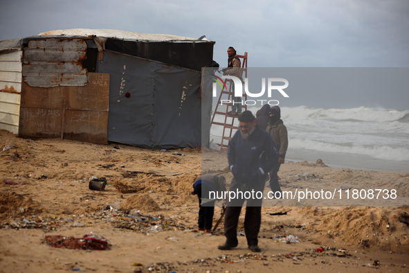 Palestinian displaced persons inspect their tents, which are damaged by wind and rain after heavy rainfall in Deir al-Balah, central Gaza St...