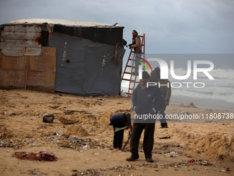 Palestinian displaced persons inspect their tents, which are damaged by wind and rain after heavy rainfall in Deir al-Balah, central Gaza St...