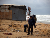 Palestinian displaced persons inspect their tents, which are damaged by wind and rain after heavy rainfall in Deir al-Balah, central Gaza St...