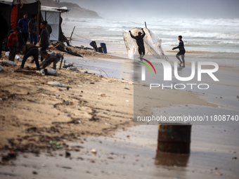 Palestinian displaced persons inspect their tents, which are damaged by wind and rain after heavy rainfall in Deir al-Balah, central Gaza St...