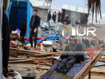 Palestinian displaced persons inspect their tents, which are damaged by wind and rain after heavy rainfall in Deir al-Balah, central Gaza St...