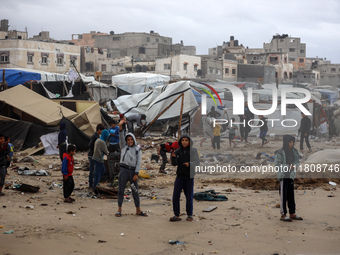 Palestinian displaced persons inspect their tents, which are damaged by wind and rain after heavy rainfall in Deir al-Balah, central Gaza St...