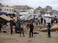 Palestinian displaced persons inspect their tents, which are damaged by wind and rain after heavy rainfall in Deir al-Balah, central Gaza St...