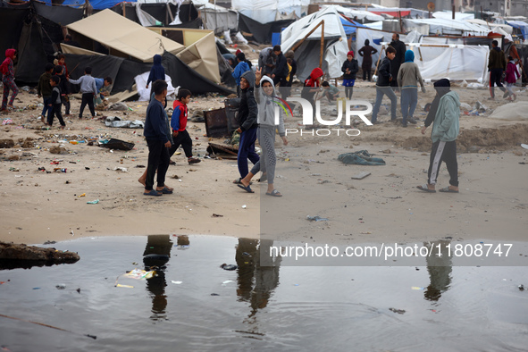 Palestinian displaced persons inspect their tents, which are damaged by wind and rain after heavy rainfall in Deir al-Balah, central Gaza St...