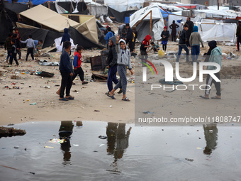 Palestinian displaced persons inspect their tents, which are damaged by wind and rain after heavy rainfall in Deir al-Balah, central Gaza St...