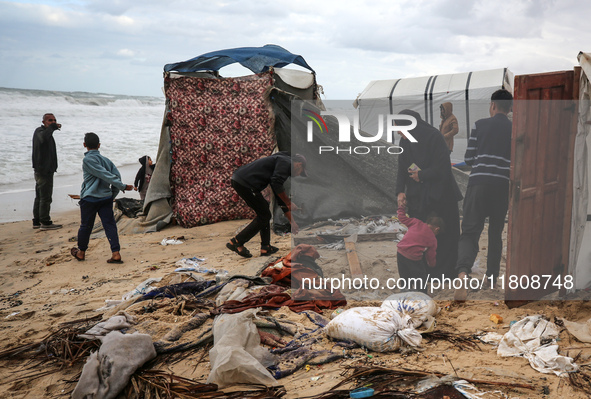 Palestinian displaced persons inspect their tents, which are damaged by wind and rain after heavy rainfall in Deir al-Balah, central Gaza St...