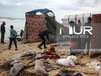 Palestinian displaced persons inspect their tents, which are damaged by wind and rain after heavy rainfall in Deir al-Balah, central Gaza St...