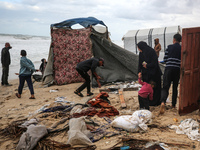 Palestinian displaced persons inspect their tents, which are damaged by wind and rain after heavy rainfall in Deir al-Balah, central Gaza St...