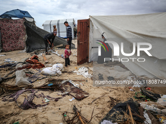 Palestinian displaced persons inspect their tents, which are damaged by wind and rain after heavy rainfall in Deir al-Balah, central Gaza St...