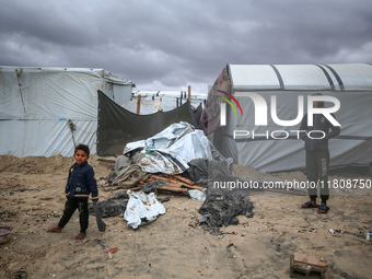 Palestinian displaced persons inspect their tents, which are damaged by wind and rain after heavy rainfall in Deir al-Balah, central Gaza St...