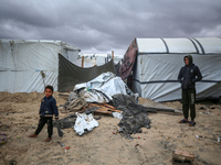 Palestinian displaced persons inspect their tents, which are damaged by wind and rain after heavy rainfall in Deir al-Balah, central Gaza St...