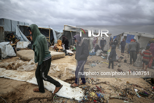 Palestinian displaced persons inspect their tents, which are damaged by wind and rain after heavy rainfall in Deir al-Balah, central Gaza St...