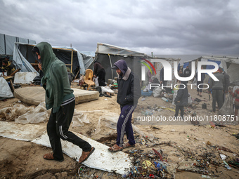 Palestinian displaced persons inspect their tents, which are damaged by wind and rain after heavy rainfall in Deir al-Balah, central Gaza St...