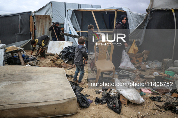 Palestinian displaced persons inspect their tents, which are damaged by wind and rain after heavy rainfall in Deir al-Balah, central Gaza St...