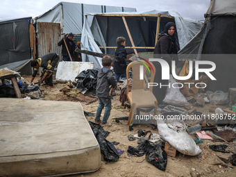 Palestinian displaced persons inspect their tents, which are damaged by wind and rain after heavy rainfall in Deir al-Balah, central Gaza St...