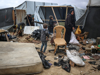 Palestinian displaced persons inspect their tents, which are damaged by wind and rain after heavy rainfall in Deir al-Balah, central Gaza St...