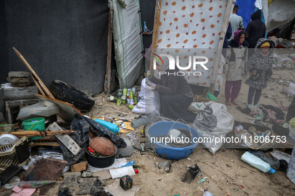 Palestinian displaced persons inspect their tents, which are damaged by wind and rain after heavy rainfall in Deir al-Balah, central Gaza St...