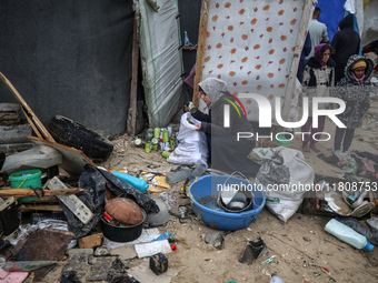 Palestinian displaced persons inspect their tents, which are damaged by wind and rain after heavy rainfall in Deir al-Balah, central Gaza St...