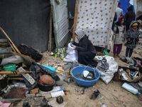 Palestinian displaced persons inspect their tents, which are damaged by wind and rain after heavy rainfall in Deir al-Balah, central Gaza St...