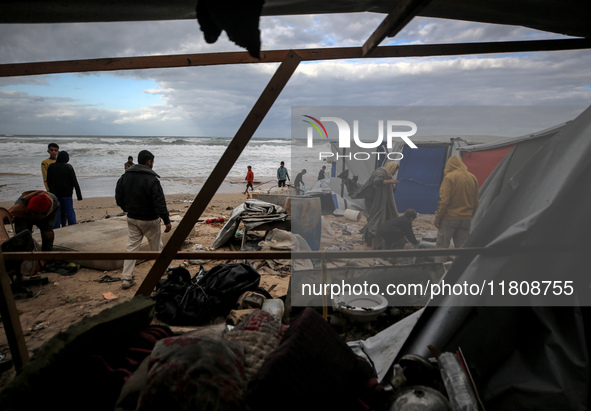 Palestinian displaced persons inspect their tents, which are damaged by wind and rain after heavy rainfall in Deir al-Balah, central Gaza St...