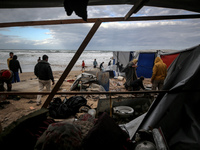 Palestinian displaced persons inspect their tents, which are damaged by wind and rain after heavy rainfall in Deir al-Balah, central Gaza St...