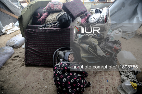 A displaced Palestinian child is inside his family's tent, which is damaged by wind and rain following heavy rainfall in Deir al-Balah, cent...