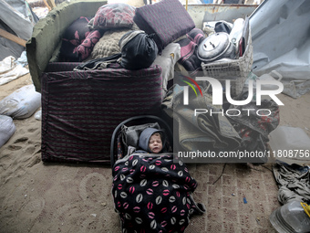 A displaced Palestinian child is inside his family's tent, which is damaged by wind and rain following heavy rainfall in Deir al-Balah, cent...