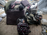 A displaced Palestinian child is inside his family's tent, which is damaged by wind and rain following heavy rainfall in Deir al-Balah, cent...