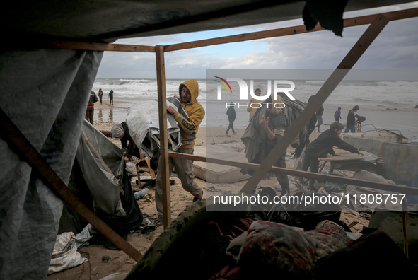 Palestinian displaced persons inspect their tents, which are damaged by wind and rain after heavy rainfall in Deir al-Balah, central Gaza St...