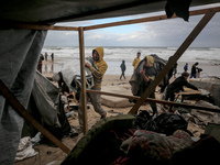 Palestinian displaced persons inspect their tents, which are damaged by wind and rain after heavy rainfall in Deir al-Balah, central Gaza St...