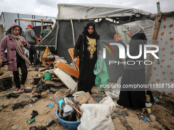 Palestinian displaced persons inspect their tents, which are damaged by wind and rain after heavy rainfall in Deir al-Balah, central Gaza St...