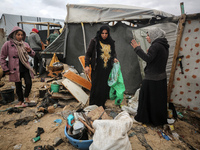 Palestinian displaced persons inspect their tents, which are damaged by wind and rain after heavy rainfall in Deir al-Balah, central Gaza St...