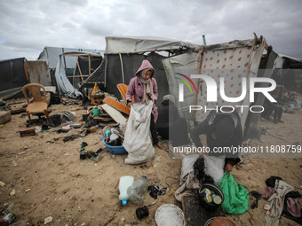 Palestinian displaced persons inspect their tents, which are damaged by wind and rain after heavy rainfall in Deir al-Balah, central Gaza St...