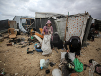 Palestinian displaced persons inspect their tents, which are damaged by wind and rain after heavy rainfall in Deir al-Balah, central Gaza St...