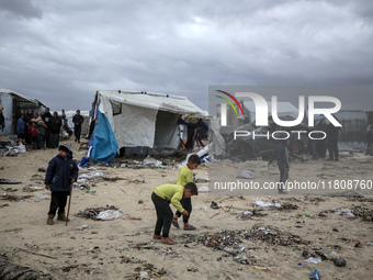 Palestinian displaced persons inspect their tents, which are damaged by wind and rain after heavy rainfall in Deir al-Balah, central Gaza St...