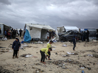 Palestinian displaced persons inspect their tents, which are damaged by wind and rain after heavy rainfall in Deir al-Balah, central Gaza St...