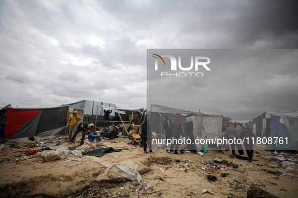 Palestinian displaced persons inspect their tents, which are damaged by wind and rain after heavy rainfall in Deir al-Balah, central Gaza St...