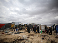 Palestinian displaced persons inspect their tents, which are damaged by wind and rain after heavy rainfall in Deir al-Balah, central Gaza St...