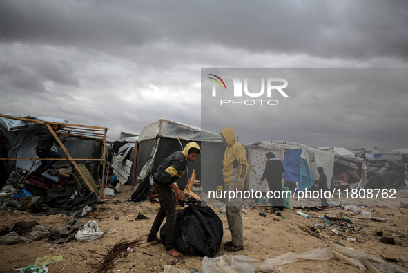 Palestinian displaced persons inspect their tents, which are damaged by wind and rain after heavy rainfall in Deir al-Balah, central Gaza St...