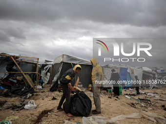 Palestinian displaced persons inspect their tents, which are damaged by wind and rain after heavy rainfall in Deir al-Balah, central Gaza St...